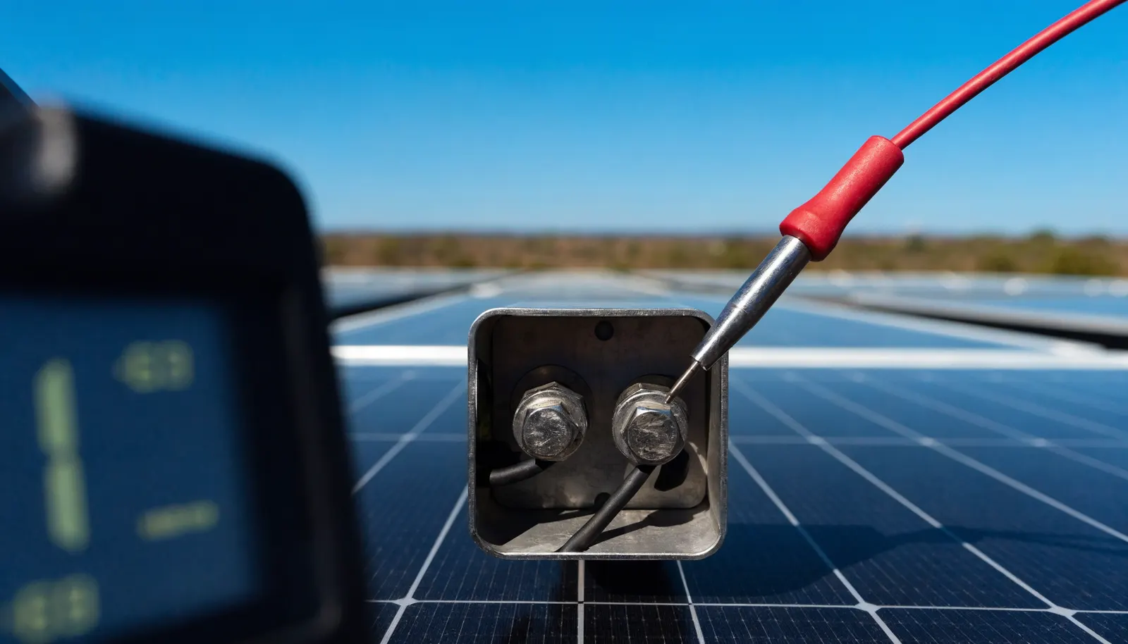 Multímetro medindo tensão em conexões elétricas de painéis fotovoltaicos em close, representando análise técnica de proposta de energia solar
